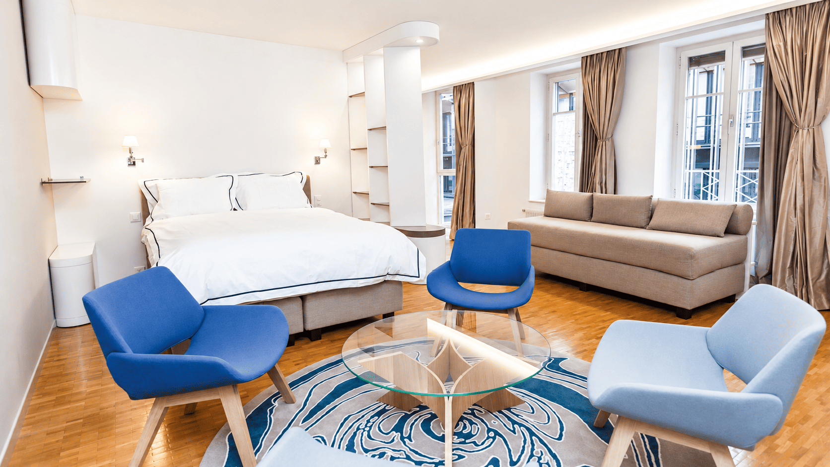 Chambre et coin salon dans un appartement à Genève, fauteuils bleus, tapis rond sur mesure et rideaux en soie, Camille Brunot