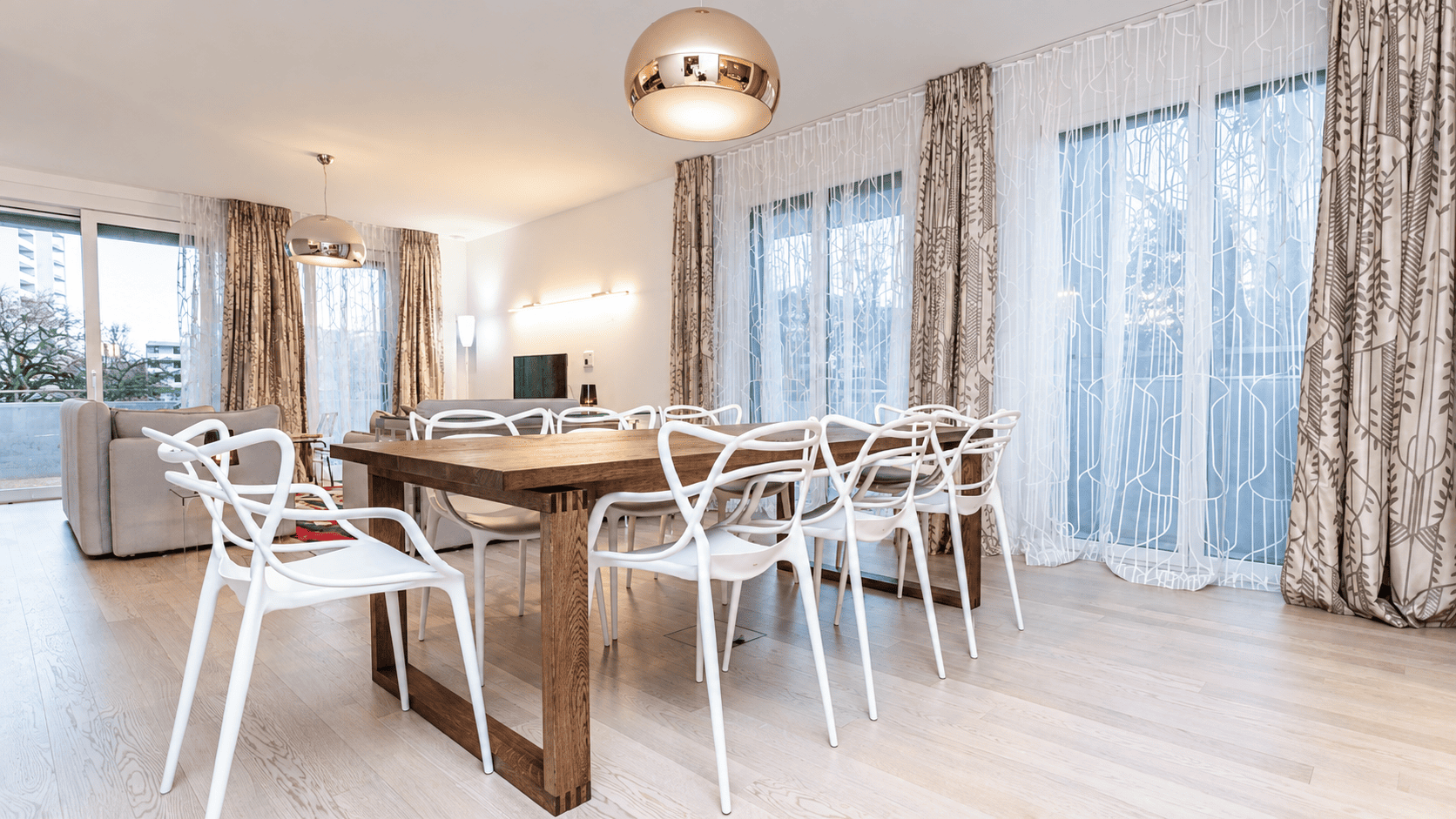 Séjour et salle à manger rénovés à Genève, voilages et rideaux sur mesure, table en bois massif et suspensions cuivrées, Camille Brunot